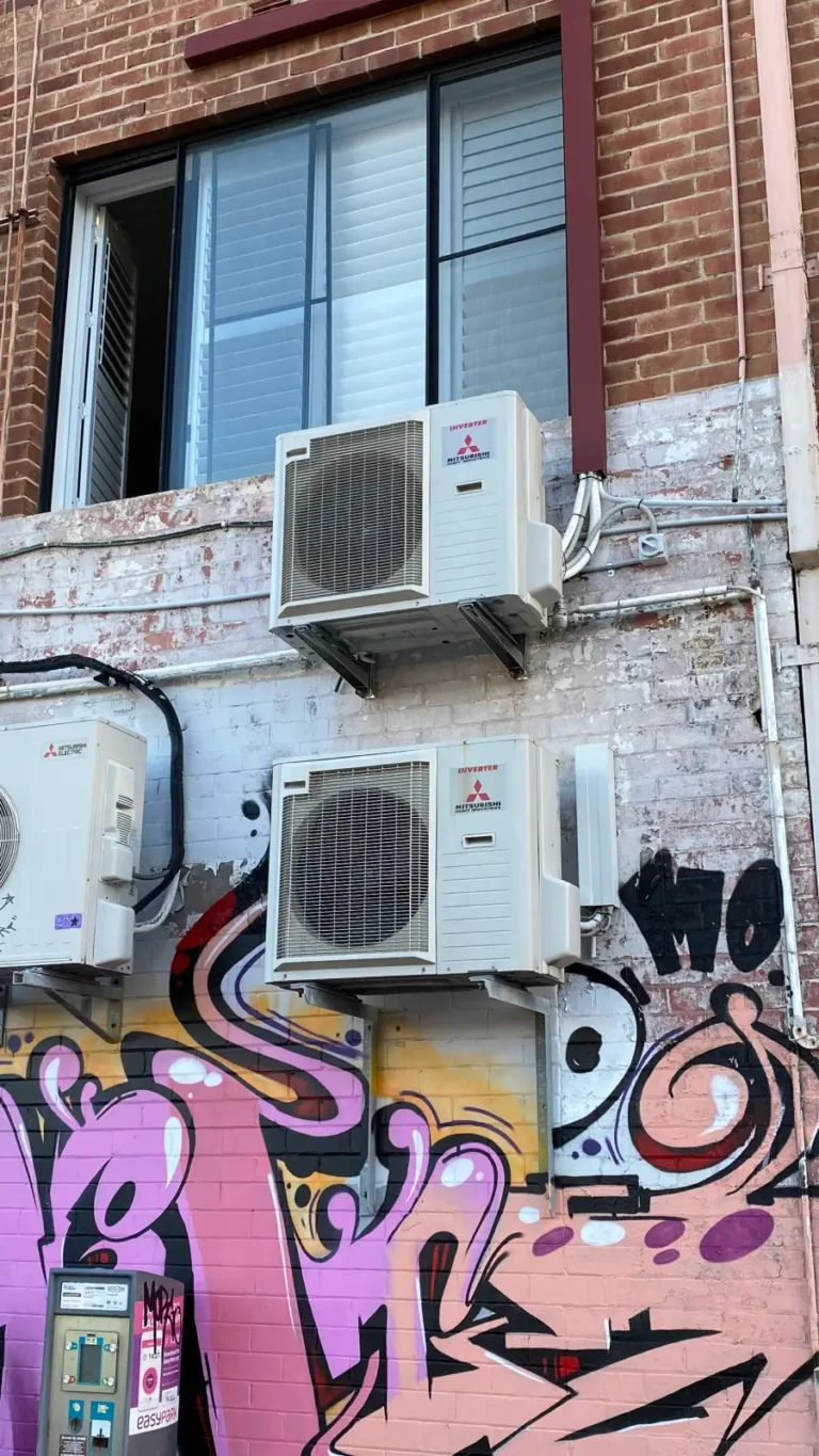 two mitsubishi split systems mounted high on a wall